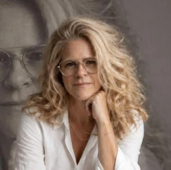 Sophie Nolin, thérapeute en relation d’aide, devant un grand portrait d’elle-même